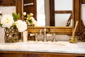 een badkamerwastafel met spiegel en een vaas met bloemen bij Strömbergs Gunnar in Oberstaufen +15 foto's