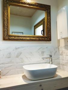 ein Badezimmer mit einem weißen Waschbecken und einem Spiegel in der Unterkunft Apartman TESLA 29, Veternik in Veternik + 32 Fotos