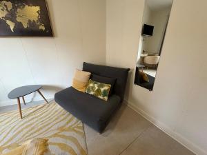 een woonkamer met een blauwe bank en een spiegel bij N1 L horizon d or in Paray-le-Monial