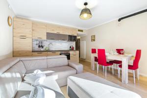 a living room with a couch and a table with red chairs at Hostdomus - La Chapelle in Sauze d'Oulx