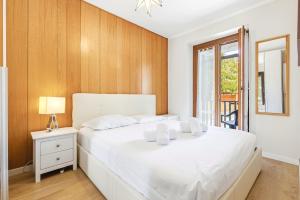a bedroom with a white bed and a window at Hostdomus - La Chapelle in Sauze d'Oulx