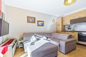 a living room with a couch and a kitchen at Hostdomus - La Chapelle in Sauze d'Oulx +14 photos