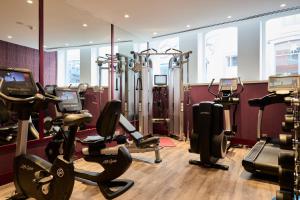 a gym with treadmills and ellipticals in a room at Catalonia Porto in Porto
