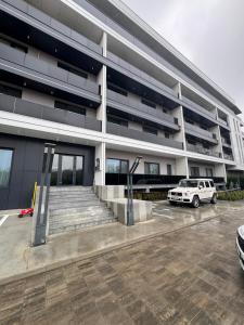 een witte auto geparkeerd voor een gebouw bij LVO Apartments in Bîrlad +9 foto's