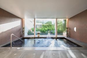 a swimming pool with a fountain in a building at Catalonia Porto in Porto