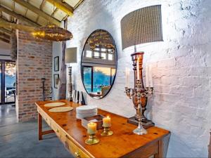a dining room with a table and a mirror at Dombeya Private Game Reserve in Vaalwater