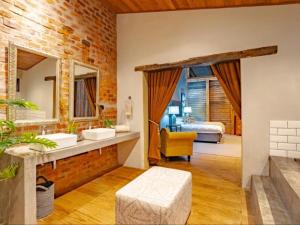 a bathroom with two sinks and a bedroom at Dombeya Private Game Reserve in Vaalwater