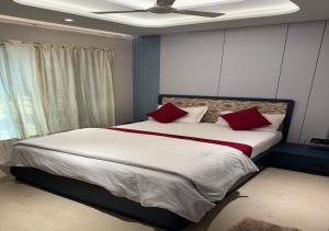 a bedroom with a large bed with red pillows at Hotel Royal Plaza in Phulabāni