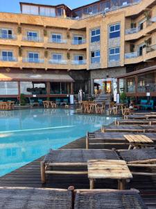 un hotel con piscina con tavoli e sedie di Château Edenelrouh a Oualidia