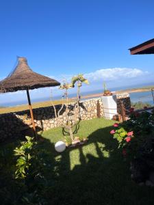 un giardino con ombrellone e vista sull'oceano di Château Edenelrouh a Oualidia