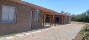 a brick building with the front door open at Casa 2 Dormitorios, Barrio El Calden in Carhué
