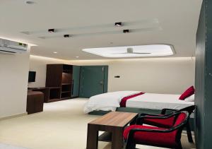a bedroom with a bed and a table and a bed at Hotel Royal Plaza in Phulabāni