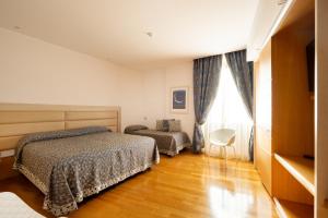a bedroom with two beds and a window at Palazzo Virgilio in Brindisi