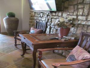 een woonkamer met een tafel en stoelen en een stenen muur bij The Orion Guesthouse in Middelburg