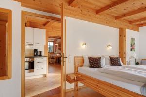 a bedroom with a large bed and a kitchen at Haldenmichelhof Ferienwohnungen in Breitnau