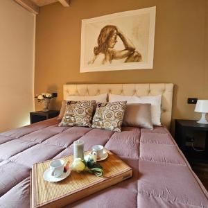 ein Bett mit einem Tablett mit zwei Tassen drauf in der Unterkunft Le STELLE SULL'ARENA in Verona