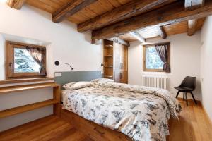 een slaapkamer met een bed en een bureau en twee ramen bij Chalet Brenand in Rhêmes-Notre-Dame