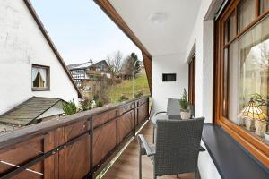 een balkon met een tafel, stoelen en een raam bij Ferienwohnung Grobbel in Schmallenberg