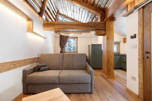 een woonkamer met een bank en houten balken bij Chalet Brenand in Rhêmes-Notre-Dame