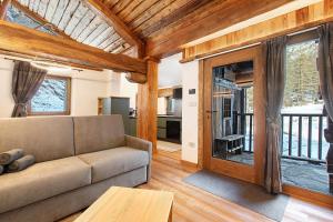 een woonkamer met een bank en glazen schuifdeuren bij Chalet Brenand in Rhêmes-Notre-Dame