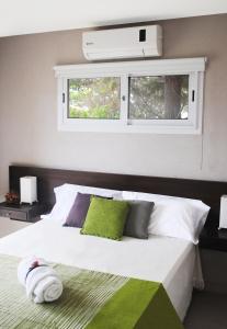 - une chambre avec un grand lit blanc et 2 fenêtres dans l'établissement Médano 29 Departamentos en alquiler, à Las Gaviotas