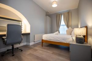 een slaapkamer met een bed, een bureau en een stoel bij Richmond Hill in Dublin