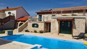 a villa with a swimming pool in front of a house at Villa Kunta by Villas Guide in Gornja Jagodnja