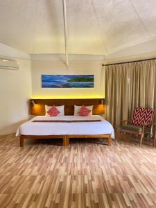 DehegilaMarahai Villa Morotai的带一张大床和一把椅子的卧室