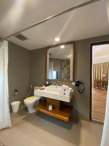 DehegilaMarahai Villa Morotai的浴室里有洗手池、马桶和镜子。