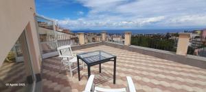 un balcone con tavolo e sedie su un edificio di La Terrazza a Patti