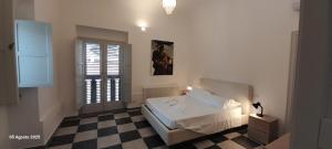 una camera da letto con un letto e un pavimento a scacchi di La Terrazza a Patti