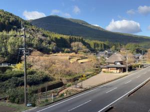 een uitzicht op een weg met een berg op de achtergrond bij IMARI HOUSE shachihoko イマリハウス しゃちほこ in Imari