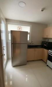 een keuken met een roestvrijstalen koelkast in een kamer bij Modern Apartment in Muscat in Muscat