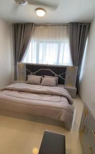 een groot bed in een kamer met een raam bij Modern Apartment in Muscat in Muscat