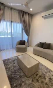 een woonkamer met 2 banken en een tapijt bij Modern Apartment in Muscat in Muscat