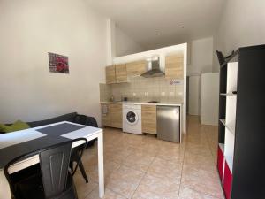 a kitchen with a washer and dryer in a room at Sisifou Apartment in Korinthos