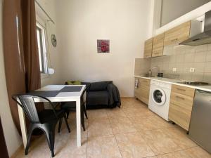 a small kitchen with a table and a washing machine at Sisifou Apartment in Korinthos