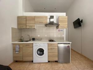 a kitchen with a washing machine and a sink at Sisifou Apartment in Korinthos