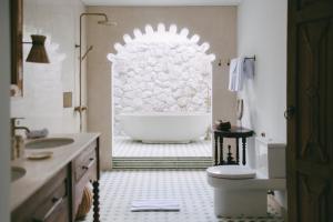 Un baño con bañera blanca y lavabo. en Calma Ubud Suite & Villas - Rice Fields View, Infinity Pool !, en Ubud