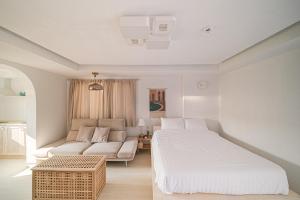 a white bedroom with a bed and a couch at 레이니데이 in Namŭm-ni +32 photos