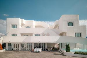 a white building with a car parked in front at 레이니데이 in Namŭm-ni