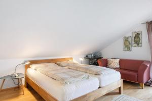 a bedroom with a bed and a red couch at Ferienwohnung Eulennestle in Lenzkirch