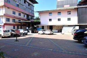 een parkeerplaats met auto's geparkeerd voor een gebouw bij Alfa Tourist Home, Batheri in Sultan Bathery +21 foto's