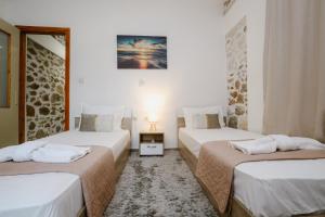 two beds in a room with white walls at luxury house in Ierapetra