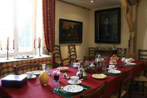 a dining room with a long table with red table cloth at Le Moulin de Montresor in Montrésor