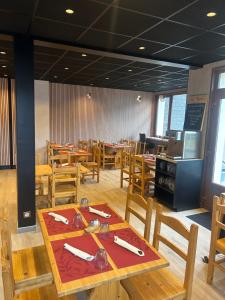 a dining room with wooden tables and wooden chairs at L'Ail des Ours in Les Estables