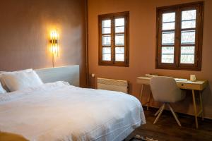 ein Schlafzimmer mit einem Bett und einem Schreibtisch mit Stuhl in der Unterkunft Αρχοντικό Παπαγιάννη in Edessa