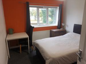 a small bedroom with two beds and a window at Millhouse Property in Bromborough