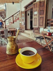een kop koffie op een geel bord op een tafel bij Stone Town Cafe in Zanzibar City