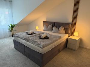 a bedroom with a large bed with two pillows on it at Rednitz Luxus House in Rednitzhembach